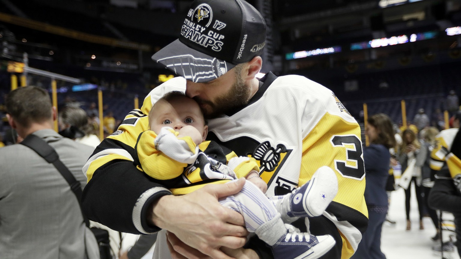 Pittsburgh Penguins defenseman Mark Streit, of Switzerland, kisses his daughter, Victoria, 5 months old, after the Penguins defeated the Nashville Predators 2-0 to win Game 6 of the NHL hockey Stanley ...