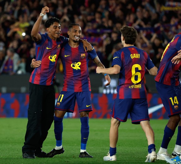 Barcelona's Lamine Yamal and Raphinha Barcelona celebrate after winning the Spanish La Liga soccer match between FC Barcelona and Real Madrid that makes them Spanish league champions in Barcelona ...