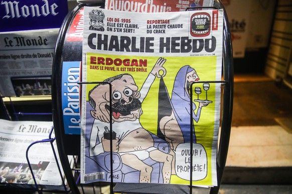 epa08781395 Copies of the new edition of the French satirical magazine Charlie Hebdo with a caricature of Turkish President Erdogan on its front page are on display at a newspaper kiosk in Paris, Fran ...