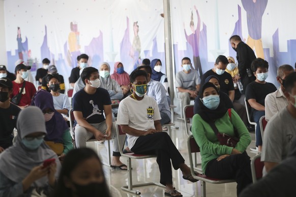 People wait before they receive a shot of the Sinovac vaccine for COVID-19 during a vaccination campaign in Jakarta, Indonesia, Monday, July 12, 2021. (AP Photo/Achmad Ibrahim)