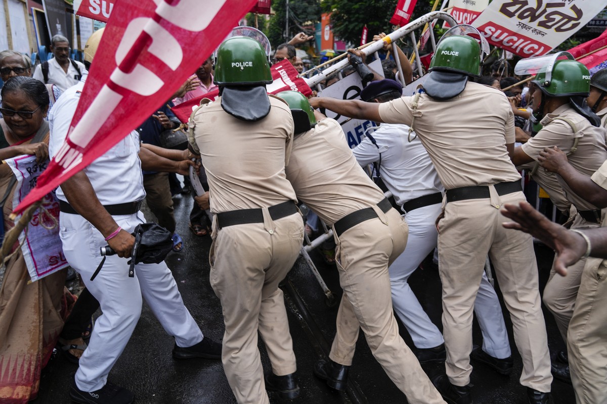 Policemen try to resist activists of Socialist Unity Center of India-Marxist (SUCI-N) from breaking a barricade during a protest against the rape and murder of a trainee doctor at a government hospita ...