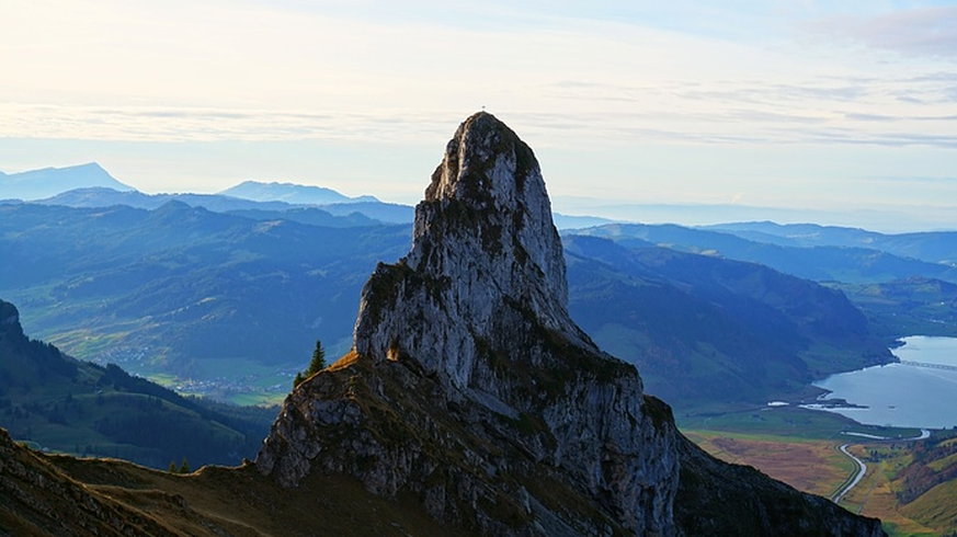 Der Wändlispitz mit dem Loch (helle Stelle im linken unteren Bereich des Fels) und im Hintergrund der Sihlsee.