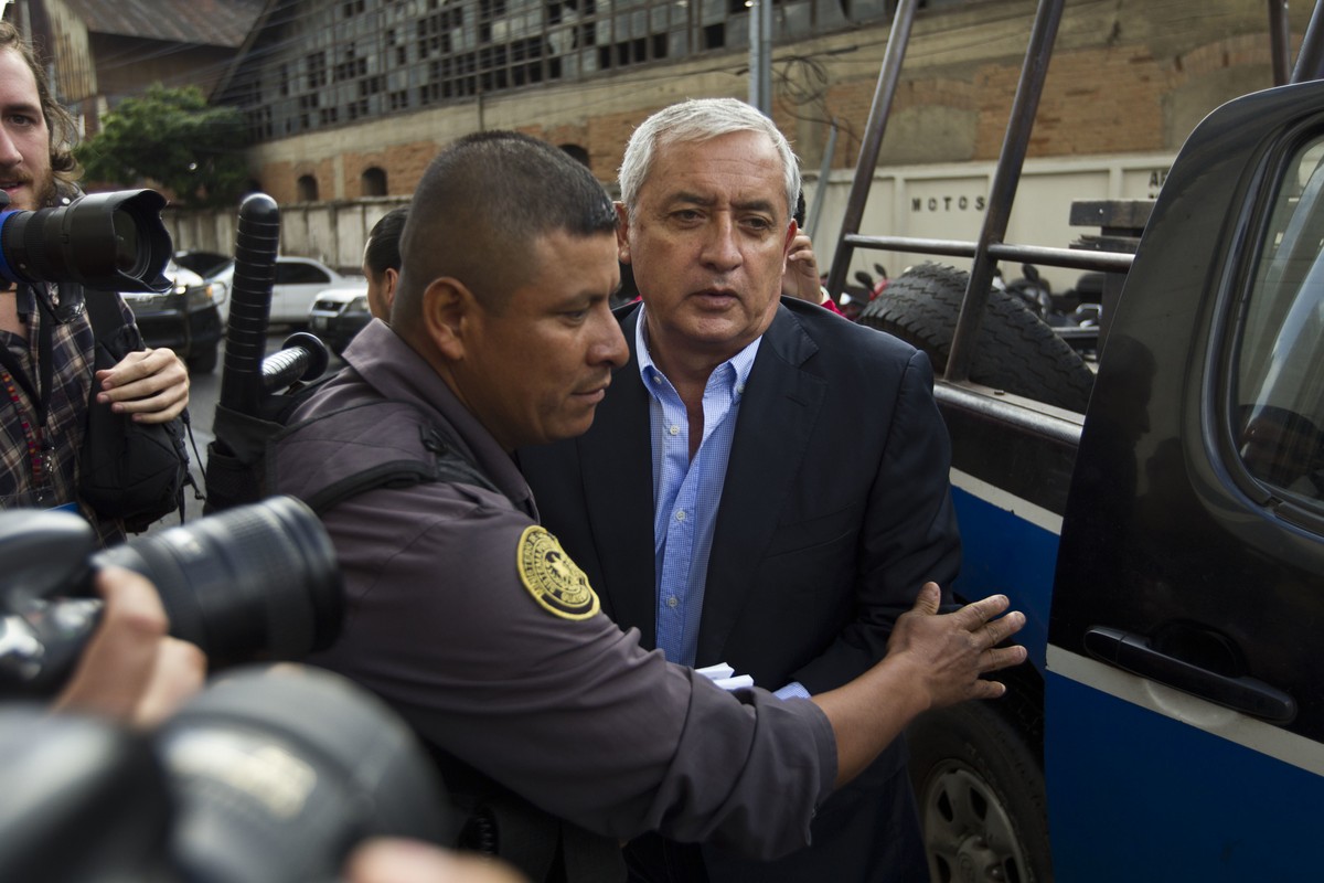 FILE - Guatemalan former President Otto Perez Molina is escorted by police into a court hearing in Guatemala City, June 13, 2016. On Monday, Jan. 17, 2022, after almost 7 years in prison, and being fo ...