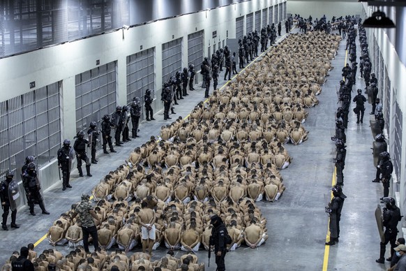 In this photo provided by El Salvador&#039;s presidential press office, inmates identified by authorities as gang members are seated on the prison floor of the Terrorism Confinement Center in Tecoluca ...