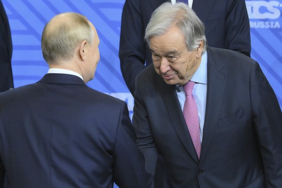 Russian President Vladimir Putin, left, and United Nations Secretary-General Antonio Guterres shake hands during family photo ceremony prior to Outreach/BRICS Plus format session on the sidelines of t ...