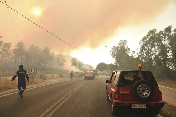 Firefighters operate during a wildfire near Lampiri village, west of Patras, Greece, Saturday, Jul. 31, 2021. The fire, which started high up on a mountain slope, has moved dangerously close to seasid ...