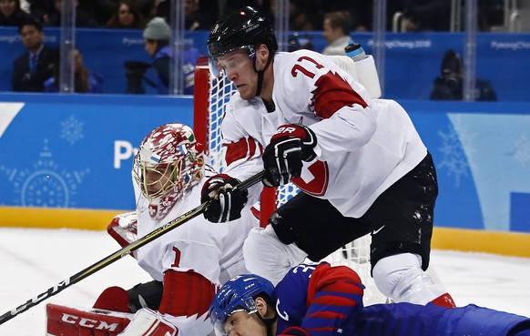 epa06535333 Jonas Hiller (L) and Enzo Corvi (R) of Switzerland block a shot against Woosang Park (C) of Republic of Korea during the men&#039;s preliminary round inside the Gangneung Hockey Centre at  ...