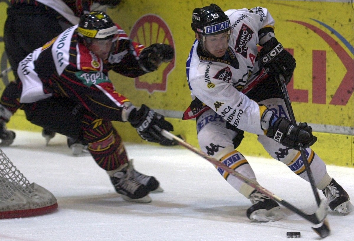 Der Langnauer Marc Buehlamnn, links, verfolgt Lugano's Jean Jacques Aeschlimann, rechts, beim NLA Eishockeymatch Lugano gegen Langnau, am Freitag, 19. Oktober 2001, in der Luganeser Eishalle Rese ...