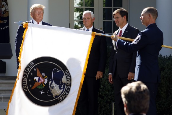 FILE _ In this Aug. 29, 2019 file photo, President Donald Trump watches with Vice President Mike Pence and Defense Secretary Mark Esper as the flag for U.S. space Command is unfurled as Trump announce ...