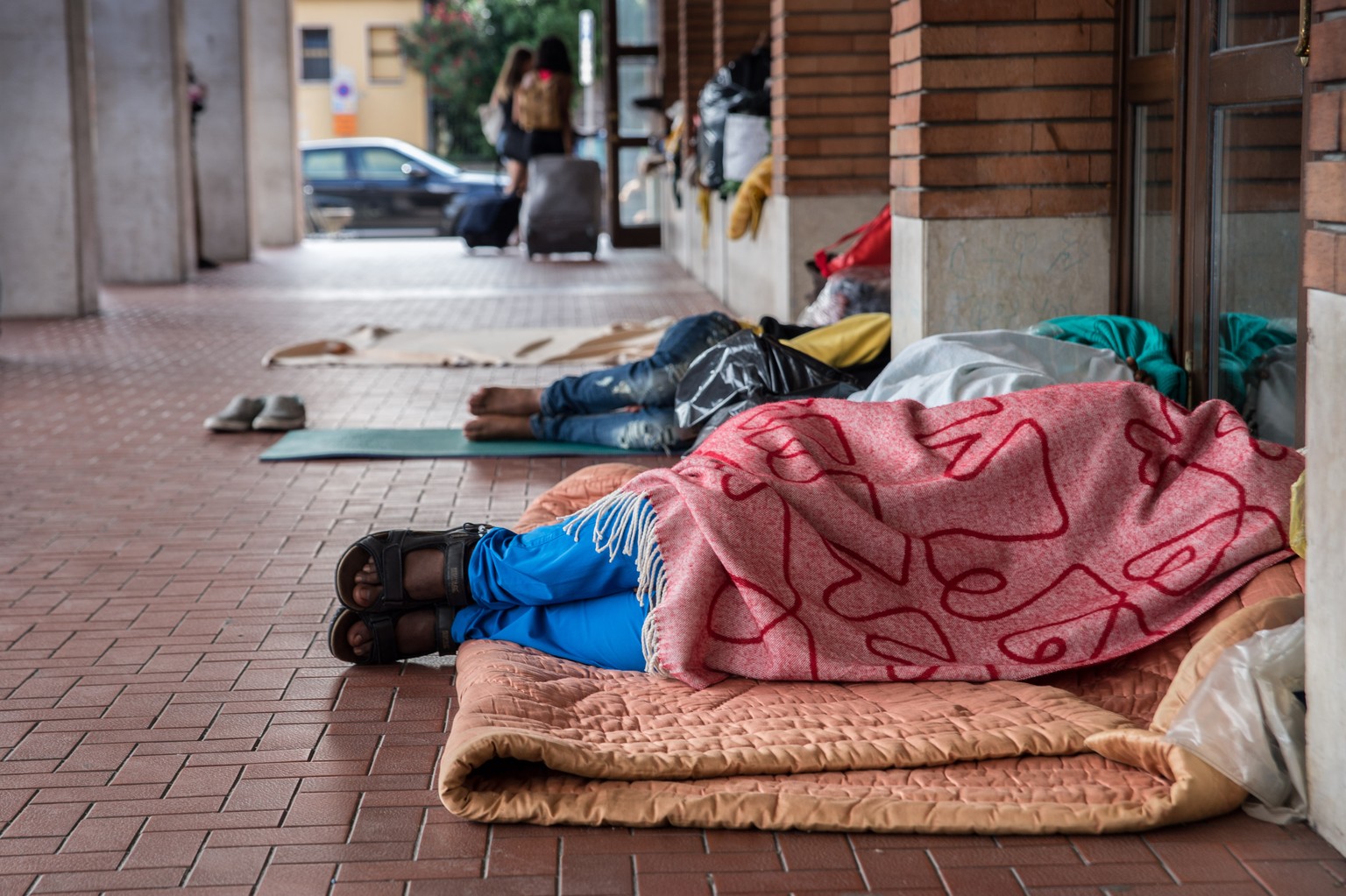 Am Boden schlafende Fluechtlinge haben sich am Bahnhof von Como niedergelassen und warten auf eine Weiterreise in die Schweiz, am Dienstag, 2. August 2016, in Como, Italien. (KEYSTONE/TI-PRESS/Frances ...