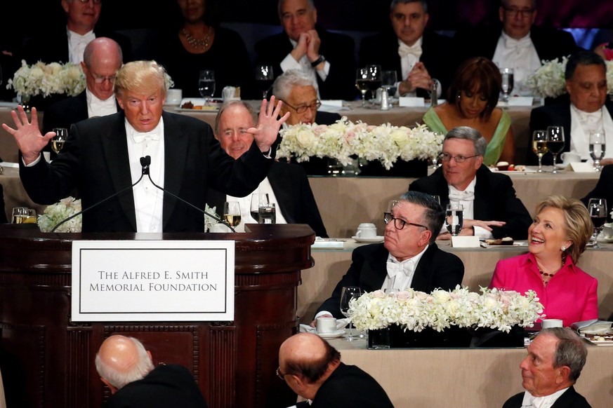 Republican U.S. presidential nominee Donald Trump (L) makes a joke about hand size as dinner chairman Alfred E. Smith IV (C) and Democratic U.S. presidential nominee Hillary Clinton react at the Alfre ...