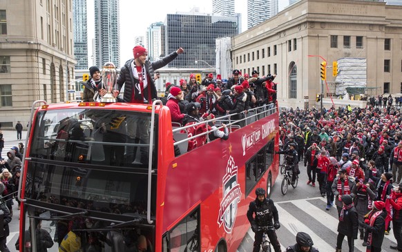 Toronto FC captain Michael Bradley, right, stands at the front of the bus alongside Sebastian Giovinco with the MLS Trophy as Toronto FC celebrates their victory in the MLS Cup final with a parade thr ...