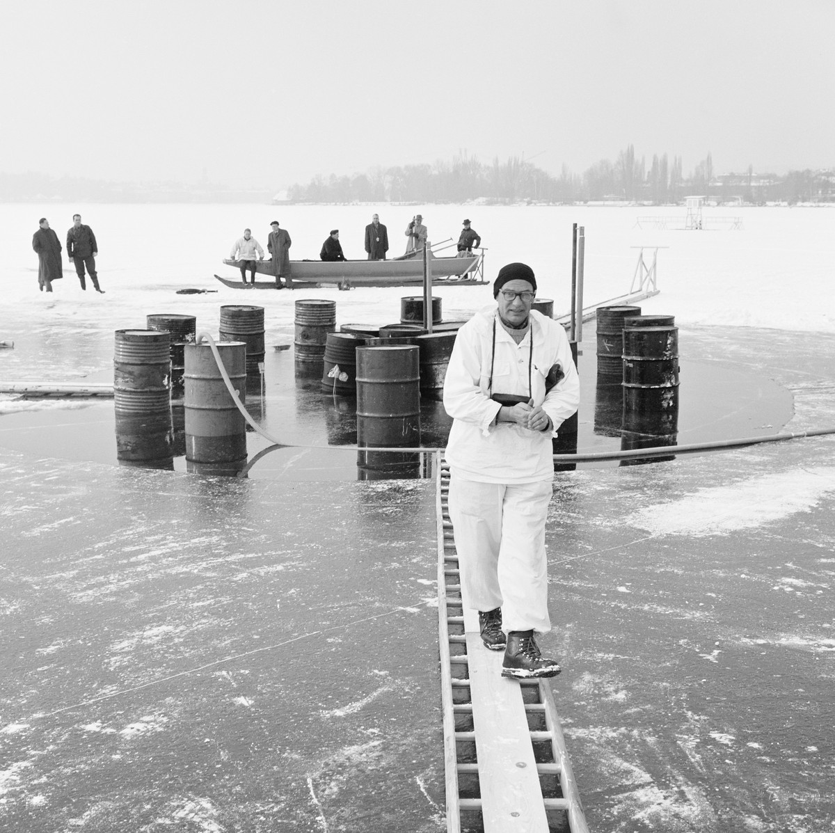Dr. Roethlisberger von der Eidgenoessischen Versuchsanstalt fuer Wasserbau und Bergbau mit den Versuchsfaessern auf dem zugefrorenen Zuerichsee, mit denen die Durchbiegung und Tragfaehigkeit des Eises ...