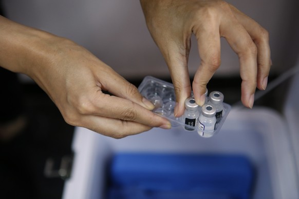 A nurse takes a vial of the Pfizer COVID-19 vaccine from the refrigerated compartment during a vaccination campaign for the 3rd dose at the vaccination center in Casablanca, Morocco, on Monday, Oct. 1 ...