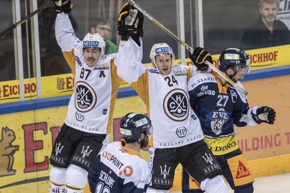 Die Lugano Spieler mit Dario Buergler, links, und Jani Lajunen, mitte, feiern das 2:3 beim Eishockey Meisterschaftsspiel in der Qualifikation der National League zwischen dem EV Zug und dem HC Lugano  ...