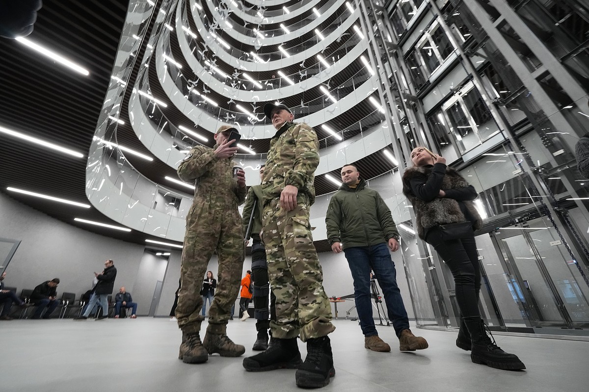 Visitors wearing military camouflage talk in the 'PMC Wagner Centre', which is associated with businessman and founder of the Wagner private military group Yevgeny Prigozhin, during the offi ...