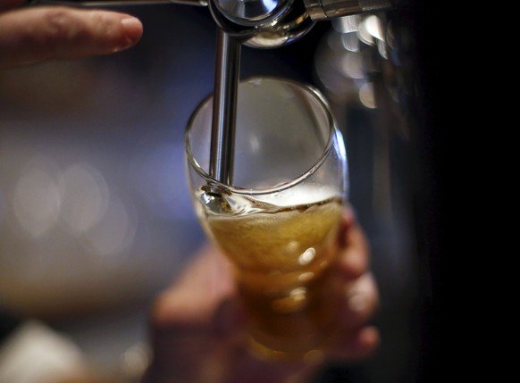 Beer Shooter franchise manager Ricardo Gil pours a glass of beer at the imported and locally-brewed craft beer shop in Madrid, Spain, March 15, 2016. Picture taken March 15, 2016. REUTERS/Juan Medina