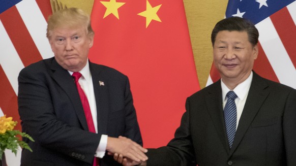 FILE - In this Nov. 9, 2017 file photo, President Donald Trump and Chinese President Xi Jinping shake hands during a joint statement to members of the media Great Hall of the People in Beijing, China. ...