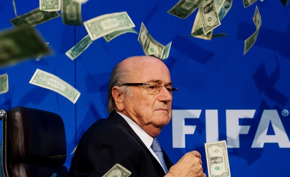 FILE - FIFA Suspend President Sepp Blatter, Michel Platini And Jerome Valcke ZURICH, SWITZERLAND - JULY 20: Comedian Simon Brodkin (not pictured) throws dollar bills at FIFA President Joseph S. Blatte ...