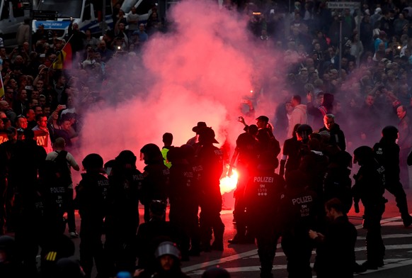 epa06977359 Right wing protesters light flares while facing police as they gather at the place where a man was stabbed in the night of the 25 August 2018, in Chemnitz, Germany, 27 August 2018. A 35-ye ...