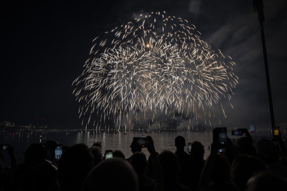 Besucher betrachten das Feuerwerk am Zueri Faescht, aufgenommen am Samstag, 8. Juli 2023 in Zuerich. An diesem Wochenende werden ueber 2,5 Millionen Besucherinnen und Besucher in der Limmatstadt erwar ...