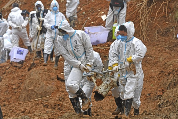 In this photo released by Xinhua News Agency, rescuers carry a piece of plane wreckage at the site of Monday&#039;s plane crash in Tengxian County, southern China&#039;s Guangxi Zhuang Autonomous Regi ...