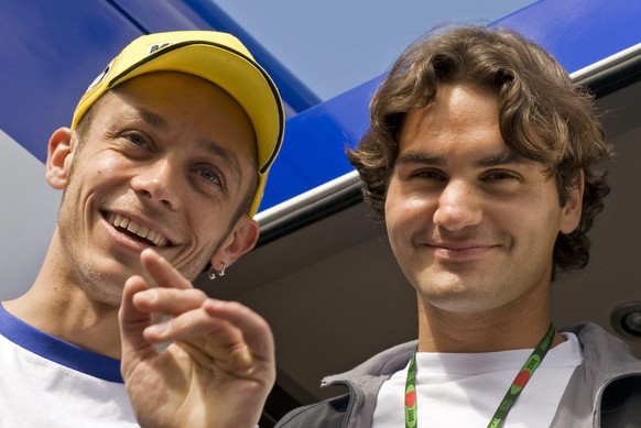 Italian MotoGP class motorcycle rider Valentino Rossi of Fiat Yamaha team, left, jokes with Swiss tennis player Roger Federer, ahead of the Motorcycle Grand Prix of Portugal, in Estoril, Portugal, Sun ...