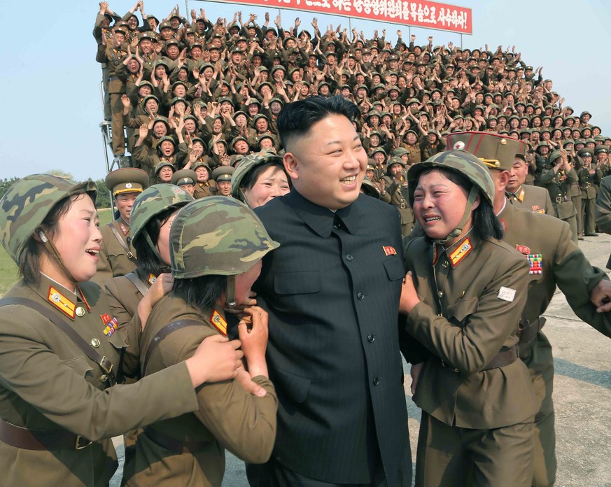 epa04177955 An undated photo made available April 24, 2014 by the North Korea Central News Agency (KCNA) shows North Korean leader Kim Jong-un (center) surrounded by women's artillery soldiers and…