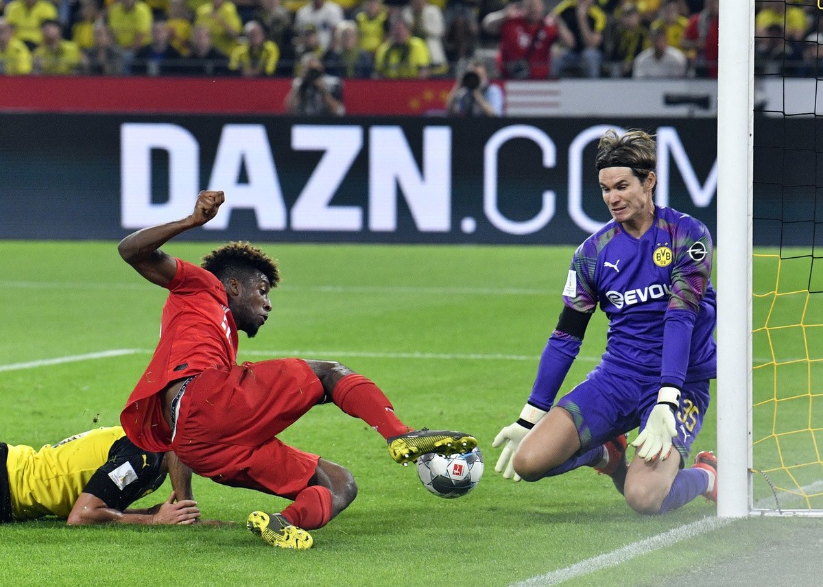 Dortmund goalkeeper Marwin Hitz, right, makes a save in front of Bayern's Kingsley Coman during the German Supercup final soccer match between Borussia Dortmund and Bayern Munich in Dortmund, Ger ...