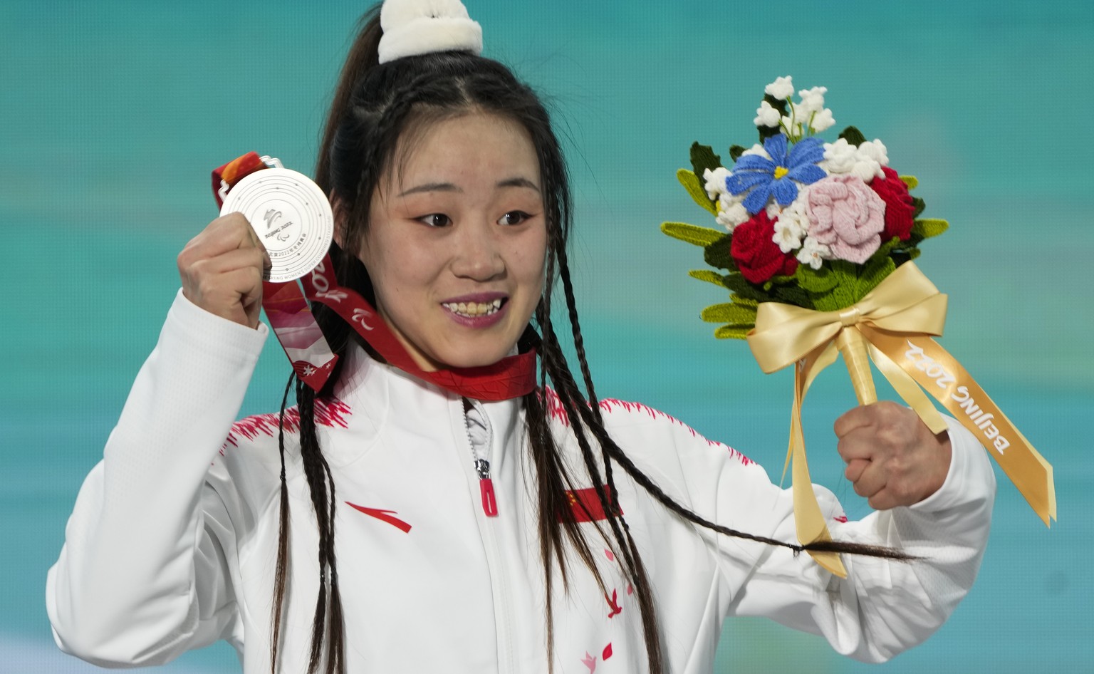 Silver medalist Zhang Mengqiu of China celebrates during the medal ceremony for the women&#039;s super combined, slalom, standing, at the 2022 Winter Paralympics, Tuesday, March 8, 2022, in the Yanqin ...