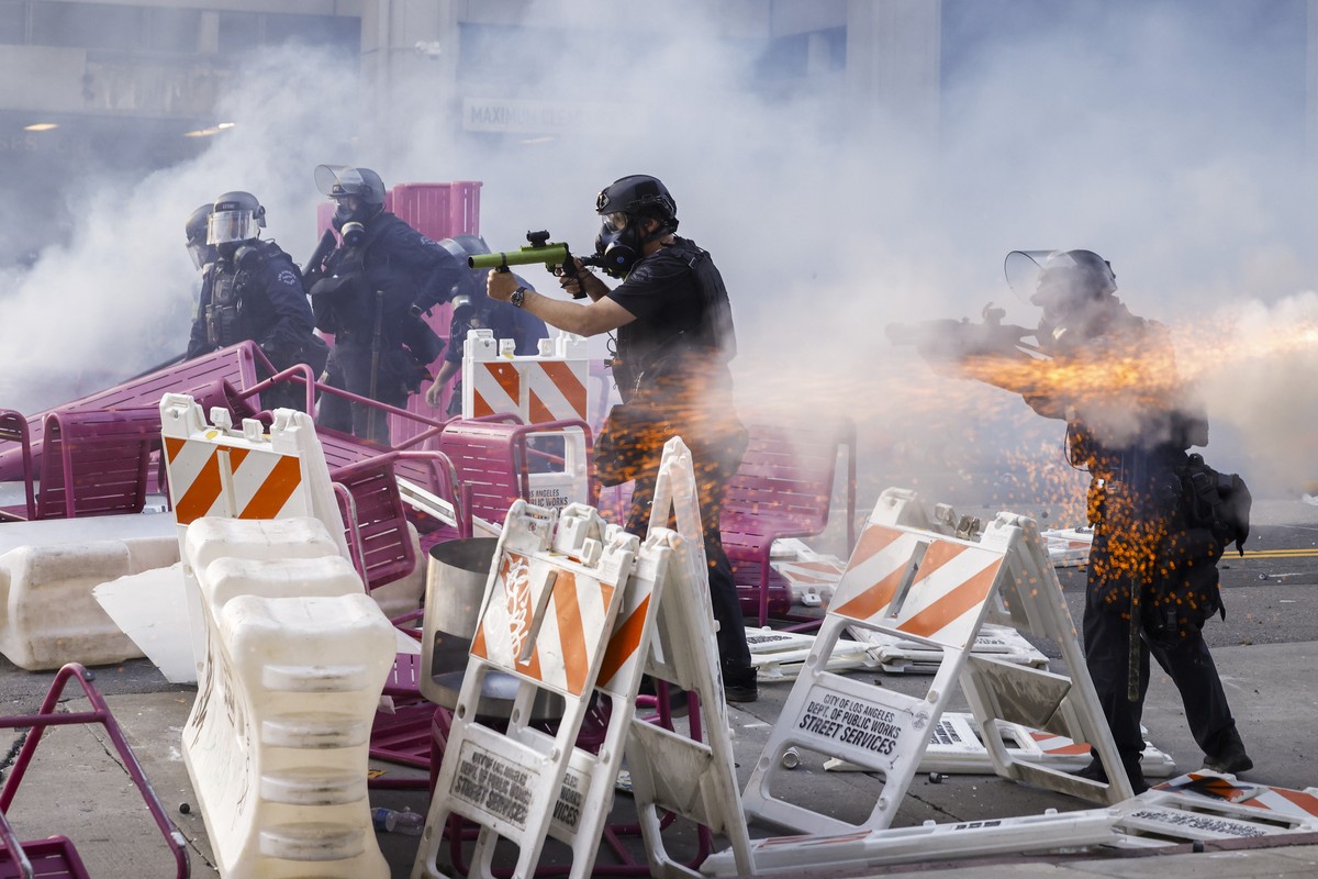 epaselect epa12165719 Police officers move to clear activists from a makeshift barricade during immigration raid protests near the Edward R. Roybal Federal Building in Los Angeles, California, USA, 08 ...