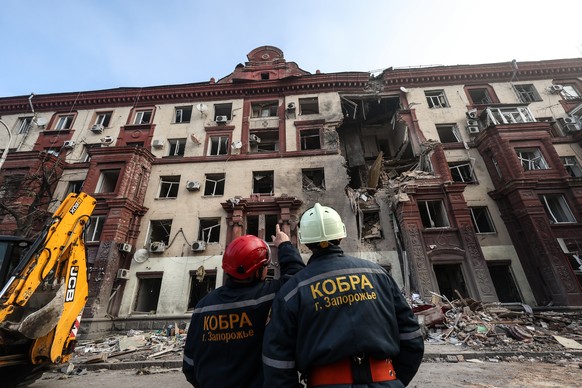 epa10925137 Rescue services attend to the scene of a residential building hit by a missile strike in, Zaporizhia, Ukraine, 18 October 2023. Two people were killed and three injured after Russia attack ...