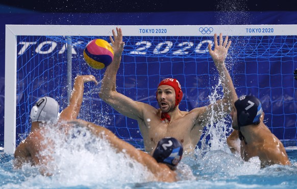 epa09405606 Christodoulos Kolomvos (L) of Greece in action against goalkeeper Branislav Mitrovic (C) of Serbia during the Men&#039;s Water Polo Gold medal match between Greece and Serbia at the Tokyo  ...