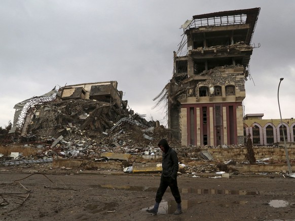 FILE -- In this Jan. 22, 2017 file photo, a student walks past badly damaged buildings at the University of Mosul, that was retaken by Iraqi security forces from Islamic State militants, on the easter ...