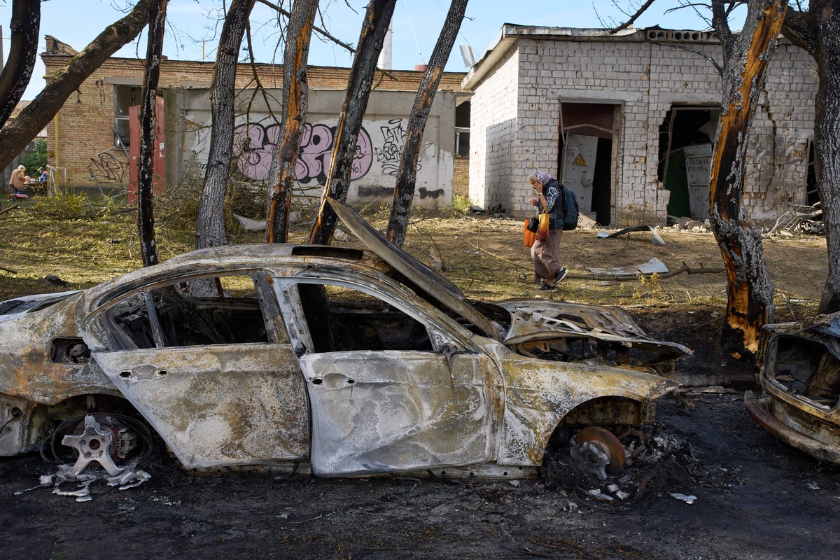 KEYPIX - A woman walks past destroyed cars following a Russian missile and drone attack in a residential area in Kyiv, Ukraine, early Tuesday, Sept. 8, 2026. (KEYSTONE/AP Photo/Francisco Seco)