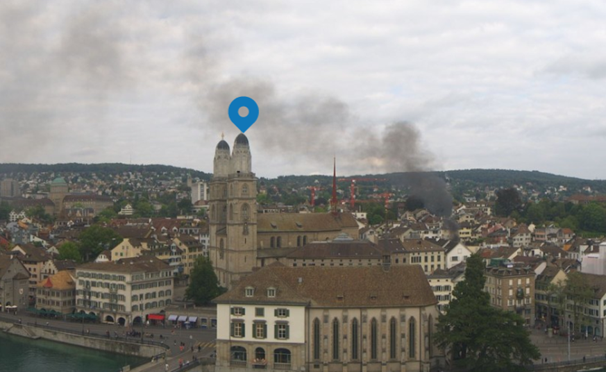 Dunkler Rauch über einem Gebäude neben dem Zürcher Grossmünster.