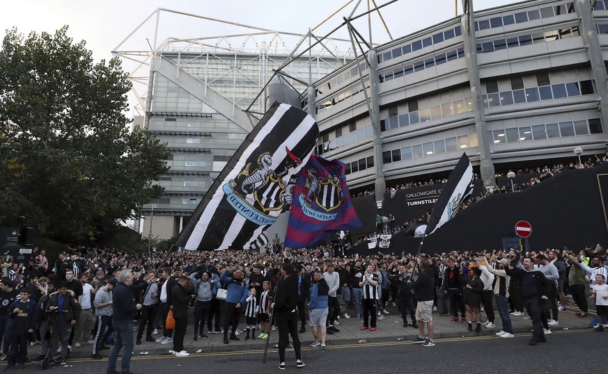 Newcastle United supporters celebrate outside St. James' Park in Newcastle Upon Tyne, England Thursday Oct. 7, 2021. English Premier League club Newcastle has been sold to Saudi Arabia