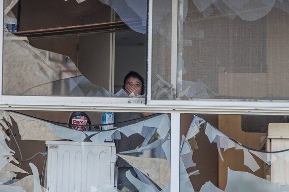240825 -- ACRE, Aug. 25, 2024 -- This photo taken on Aug. 25, 2024 shows a woman standing in a building hit directly by a rocket fired from Lebanon overnight, in the northern Israeli city of Acre. Hez ...