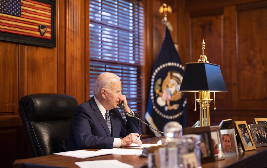 epa09660970 A handout photo made available by the White House showing US President Joe Biden speaking on the phone with Russian President Vladimir Putin on the phone from his residence in Wilmington,  ...