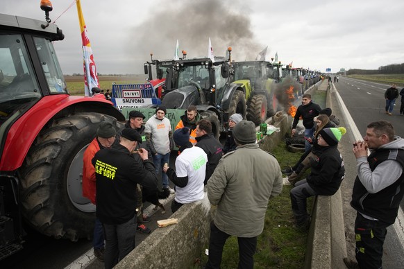 Farmers share a quick lunch as they block a highway Tuesday, Jan. 30, 2024 in Jossigny, east of Paris. With protesting farmers camped out at barricades around Paris, France&#039;s government hoped to  ...