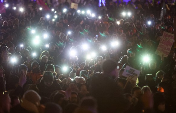 January 15, 2024, Saxony, Leipzig: numerous participants shine the flashlights on their mobile phones