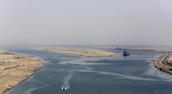 FILE - An army zodiac secures the entrance of a new section of the Suez Canal in Ismailia, Egypt, Aug. 6, 2015. Cash-strapped Egypt increased transit fees Tuesday, March 1, 2022, for ships passing thr ...