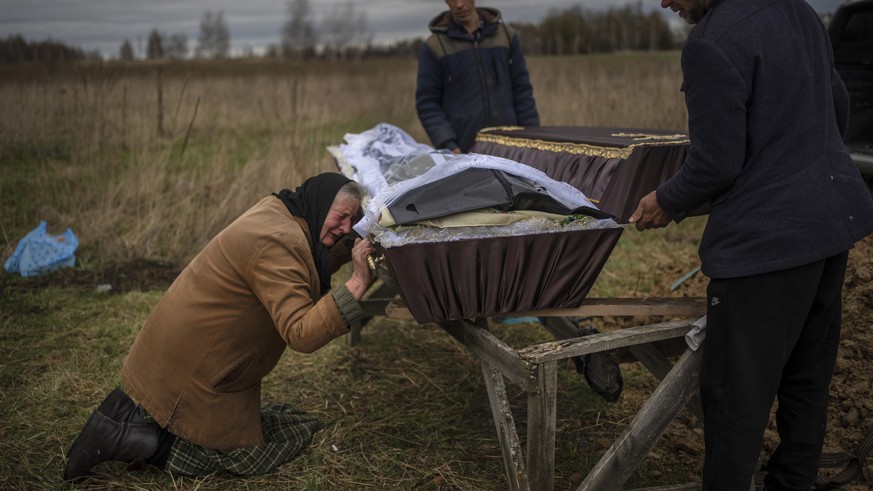 Nadiya Trubchaninova, 70, cries while holding the coffin of her son Vadym, 48, who was killed by Russian soldiers last March 30 in Bucha, during his funeral in the cemetery of Mykulychi, on the outski ...