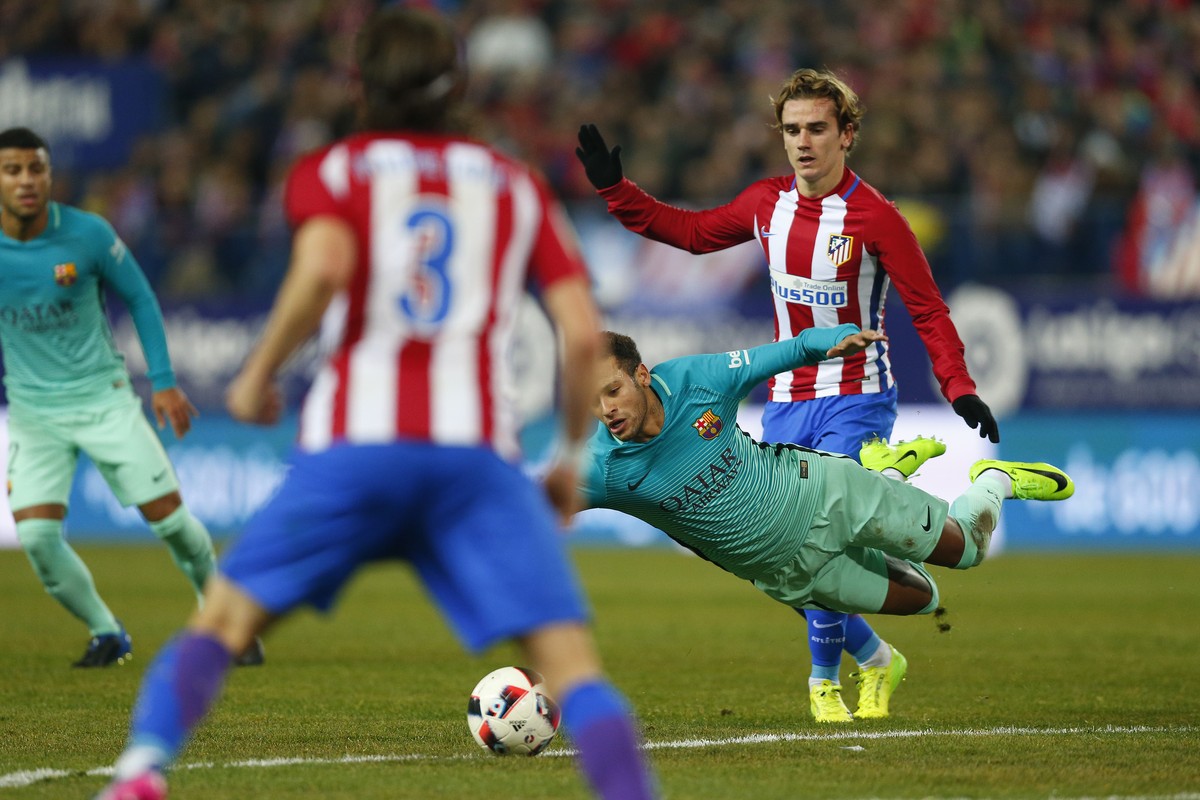 FC Barcelona's Neymar, falls in front of Atletico de Madrid Antoine Griezmann during a Spanish Copa del Rey semifinal first round soccer match between Atletico de Madrid and FC Barcelona at the V ...