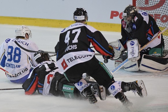 Die Fribourger Torhueter Benjamin Conz, Robin Fuchs und Sebastian Schilt, von rechts, und der Zuger Sven Senteler, links, kaempfen um den Puck im Swiss Ice Hockey Cup Viertel-Finalspiel zwischen dem H ...