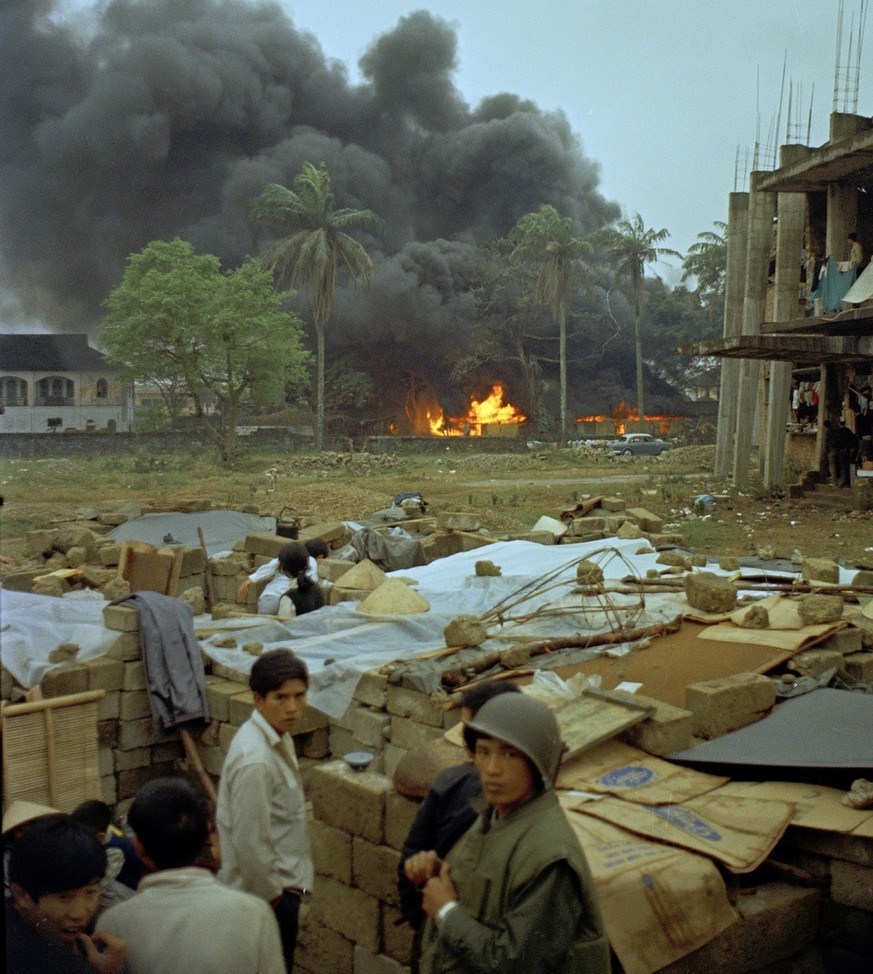 Smoke and fire from napalm strikes on the Citadel can be seen during the Tet Offensive in Hue, Vietnam, Feb. 17, 1968. (AP Photo/Al Chang)
