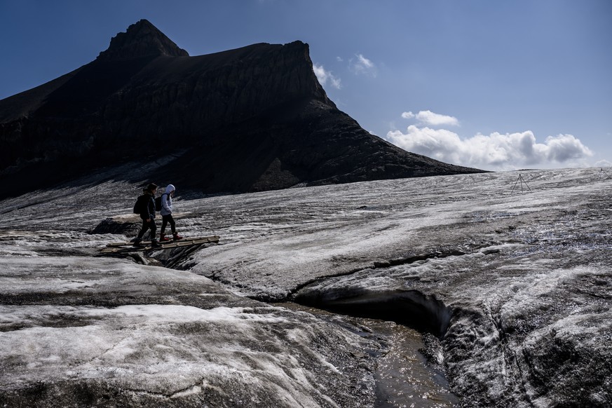 epa10095461 Hikers walk on the Scex Rouge Glacier at the &#039;Glacier 3000&#039; alpine resort, above Les Diablerets, Switzerland, 28 July 2022. The Swiss Glacier Monitoring Switzerland (GLAMOS), fea ...
