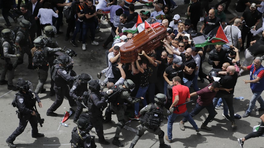 Israeli police confront with mourners as they carry the casket of slain Al Jazeera veteran journalist Shireen Abu Akleh during her funeral in east Jerusalem, Friday, May 13, 2022. Abu Akleh, a Palesti ...