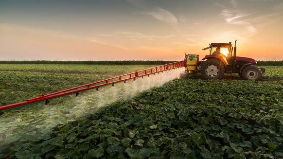 Traktor versprüht Pestizide.