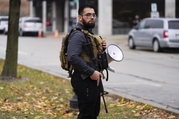 A protester carries a rifle outside the Kenosha County Courthouse, Wednesday, Nov. 17, 2021 in Kenosha, Wis., during the Kyle Rittenhouse murder trial. Rittenhouse is accused of killing two people and ...